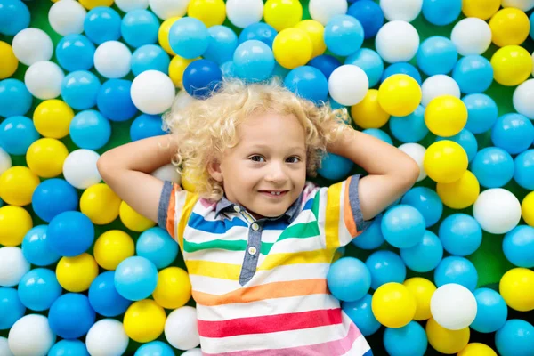 Los niños juegan en el hoyo. Niño jugando en la piscina bolas — Foto de Stock