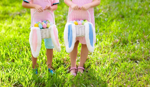 Enfants avec panier d'œufs sur la chasse aux œufs de Pâques . — Photo