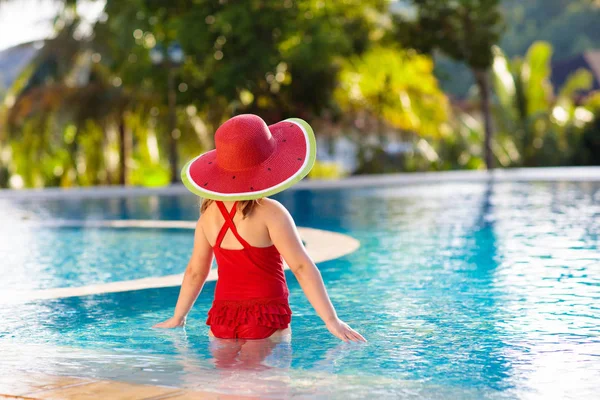 Child with hat in swimming pool. Tropical vacation — Stock Photo, Image
