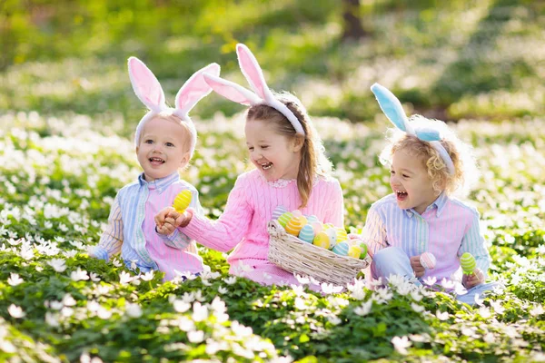 Dzieci z bunny uszy na Easter egg hunt. — Zdjęcie stockowe