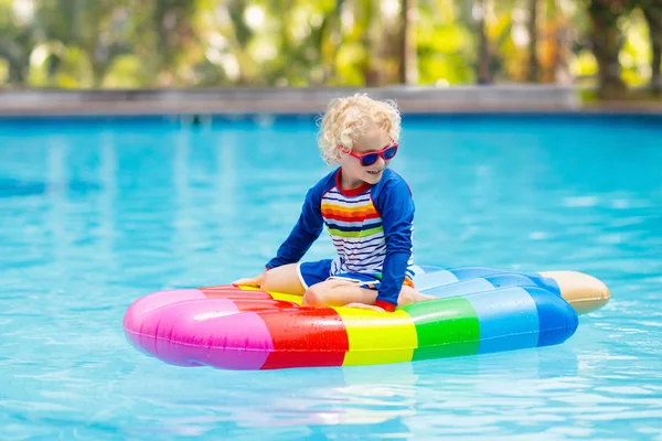Kind op opblaasbare float in zwembad. — Stockfoto