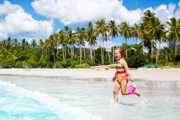 As crianças brincam na praia tropical. Brinquedo de areia e água . — Fotografia de Stock