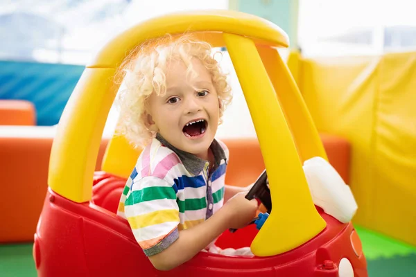 Niño montar coche de juguete. Niño pequeño con juguetes . —  Fotos de Stock