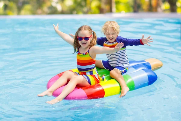 Kids on inflatable float in swimming pool. — Stock Photo, Image