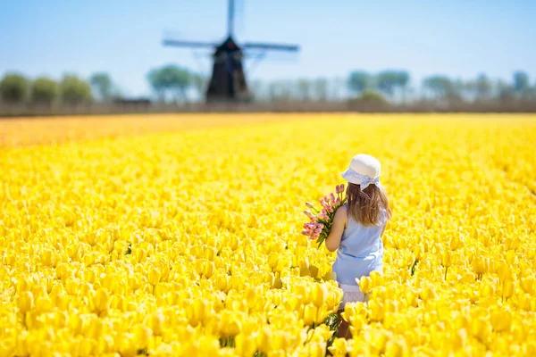 Crianças no campo de flores de tulipa. Moinho de vento em Holland — Fotografia de Stock