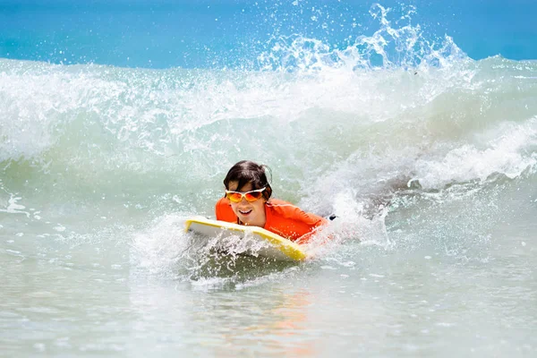 Dziecko, surfing na tropikalnej plaży. Surfer w ocean. — Zdjęcie stockowe