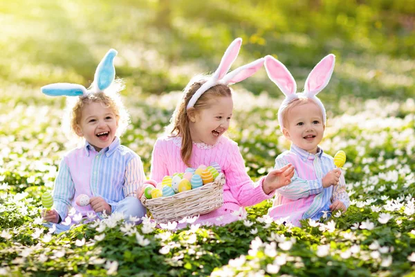 Kids with bunny ears on Easter egg hunt. — Stock Photo, Image