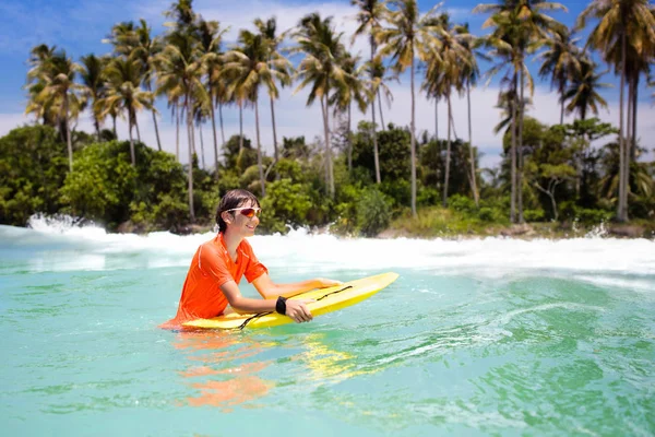 Kind surfen op tropisch strand. Surfer in Oceaan. — Stockfoto