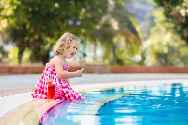 Bambina che beve succo di frutta in piscina — Foto Stock