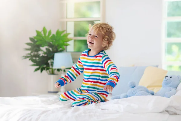 Criança brincando na cama. Quarto de crianças. Menino em casa . — Fotografia de Stock