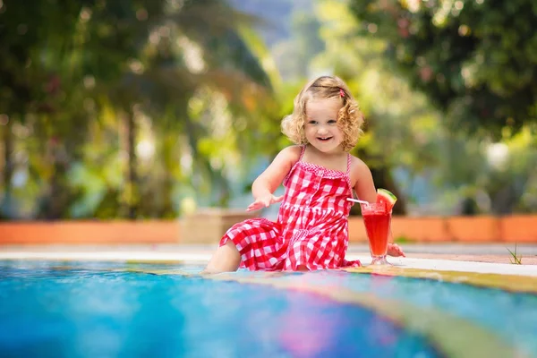 Lilla flickan dricka saft på en pool — Stockfoto