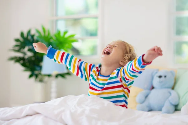 Barn som leker i sängen. Barntyger. Baby pojke hemma. — Stockfoto