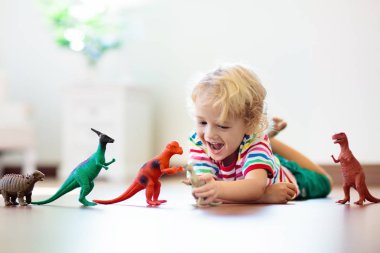 Oyuncak dinozorlar ile oynayan çocuk. Çocuklar oyuncak.