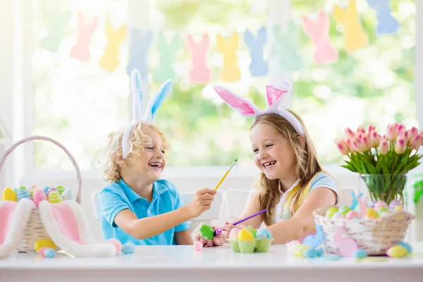 Des enfants en chasse aux œufs de Pâques. Enfants teindre les œufs . — Photo