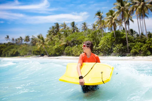 Child surfing on tropical beach. Surfer in ocean. — Stock Photo, Image