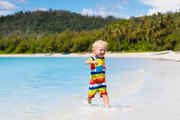 子供たちは、熱帯のビーチで遊ぶ。砂と水のグッズ. — ストック写真