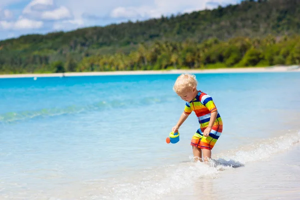 As crianças brincam na praia tropical. Brinquedo de areia e água . — Fotografia de Stock