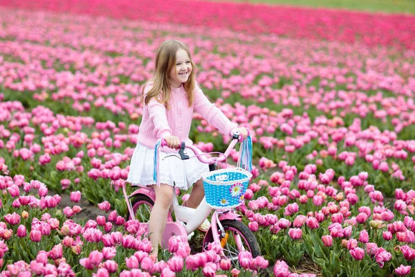 Kind op fiets in tulp veld. Fiets in Nederland. — Stockfoto