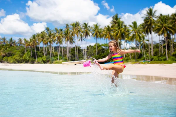 子供たちは、熱帯のビーチで遊ぶ。砂と水のグッズ. — ストック写真