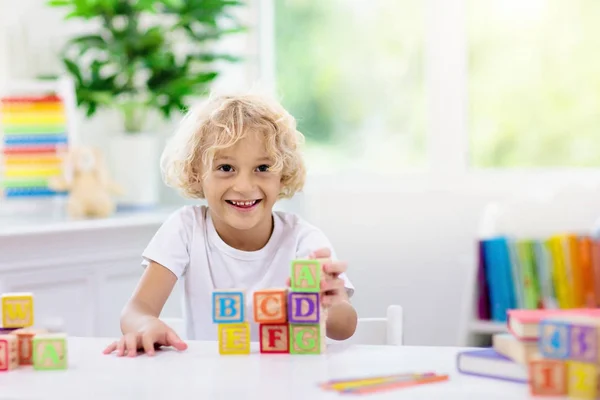 Letras de aprendizaje infantil. Niño con bloques de madera abc —  Fotos de Stock