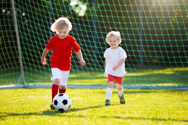 Os miúdos jogam futebol. Criança no campo de futebol . — Fotografia de Stock