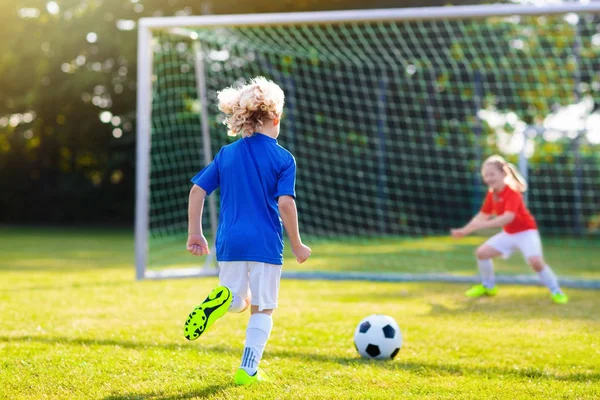 Kids play football. Child at soccer field.