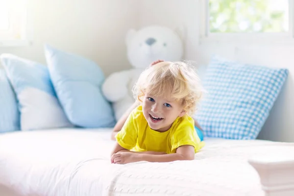 Kind spelen in bed. Kinderkamer. Babyjongen thuis. — Stockfoto