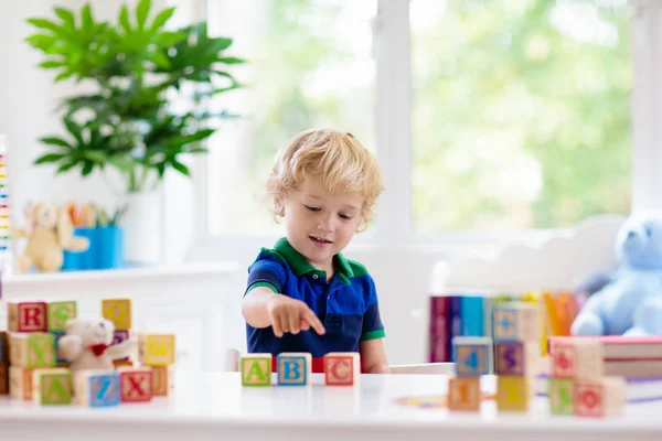 Letras de aprendizaje infantil. Niño con bloques de madera abc — Foto de Stock