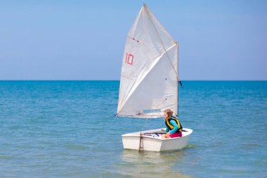 Çocuk yelkenlisi. Deniz yatında yelken açmayı öğrenen çocuk.