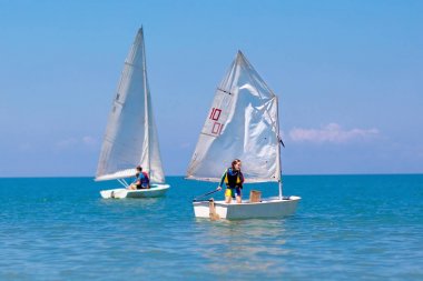 Çocuk yelkenlisi. Deniz yatında yelken açmayı öğrenen çocuk.