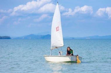Çocuk yelkenlisi. Deniz yatında yelken açmayı öğrenen çocuk.