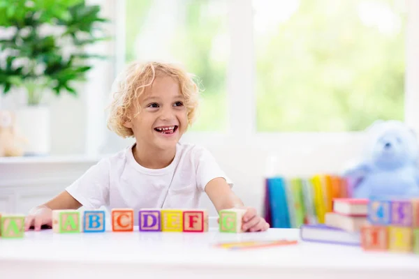 Lettere per bambini. Ragazzo con blocchi di abc in legno — Foto Stock