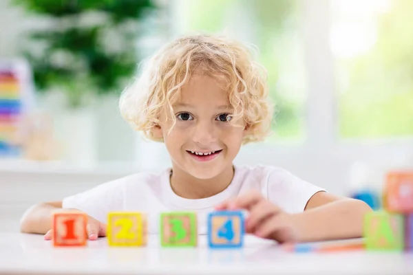 Letras de aprendizaje infantil. Niño con bloques de madera abc — Foto de Stock