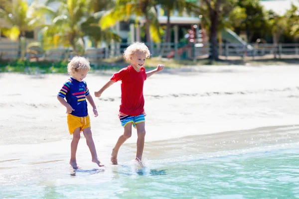 Niños jugando en la playa. Los niños juegan en el mar . —  Fotos de Stock