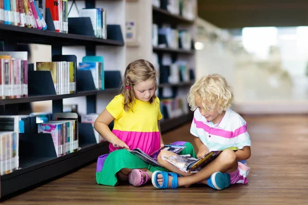 Bambino nella biblioteca della scuola. Bambini che leggono libri . — Foto Stock