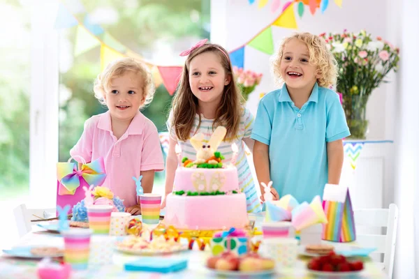 Fiesta de cumpleaños de niños. Los niños soplan velas de pastel . —  Fotos de Stock