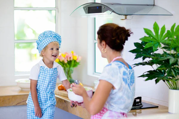 Mother and child cook. Mom and kid cook in kitchen — Stock Photo, Image