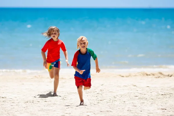 Gyerekek játszanak a strandon. Gyermekek játszanak a tengeren. — Stock Fotó