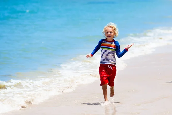 Niños jugando en la playa. Los niños juegan en el mar . —  Fotos de Stock