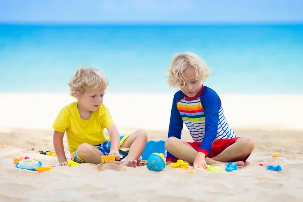 Niños jugando en la playa. Los niños juegan en el mar . — Foto de Stock