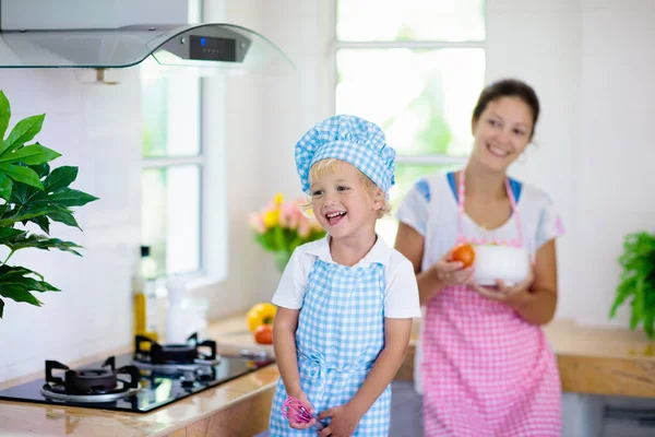 母亲和孩子做饭。妈妈和孩子在厨房做饭 — 图库照片