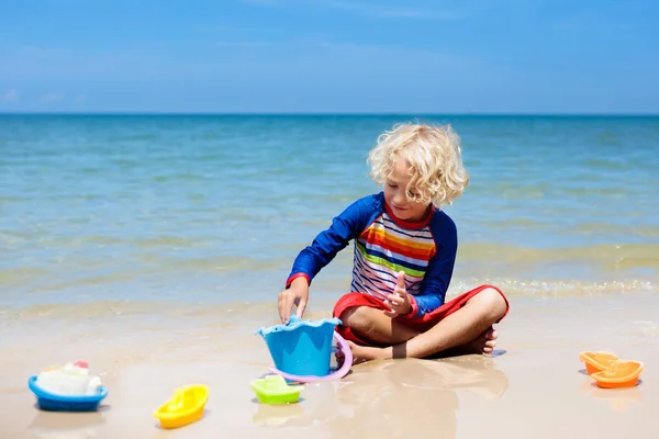 Niños jugando en la playa. Los niños juegan en el mar . —  Fotos de Stock