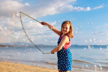 Çocuklar sahilde balonpatlatmaya. Kabarcıklar ile Çocuk