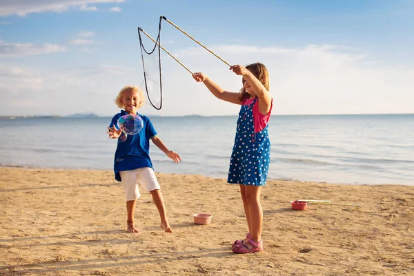 Kids blow bubble at beach. Child with bubbles — Stock Photo, Image