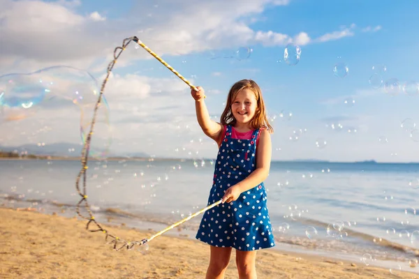 Kids blow bubble at beach. Child with bubbles — Stock Photo, Image