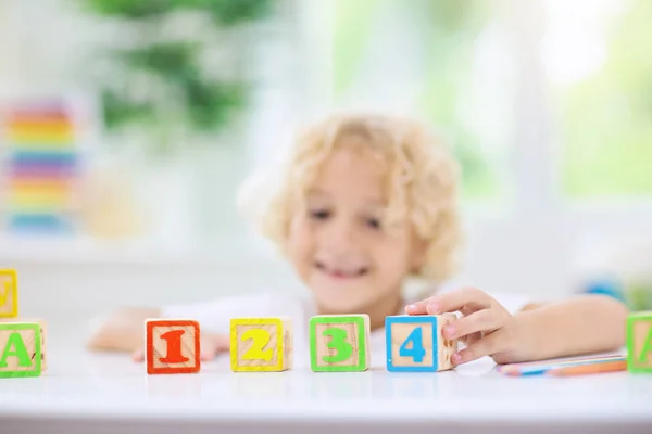 Letras de aprendizaje infantil. Niño con bloques de madera abc —  Fotos de Stock