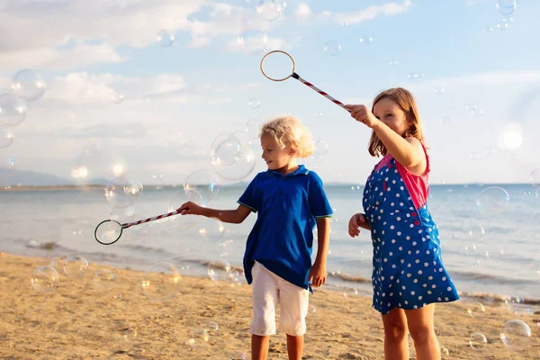 I bambini soffiano bolle in spiaggia. Bambino con bolle — Foto Stock