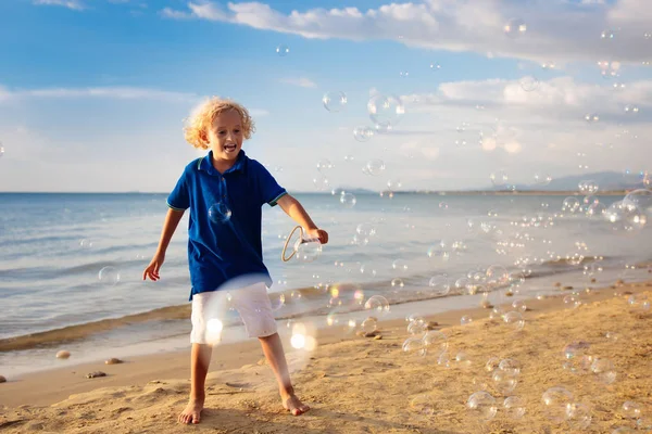 Kids blow bubble at beach. Child with bubbles — Stock Photo, Image