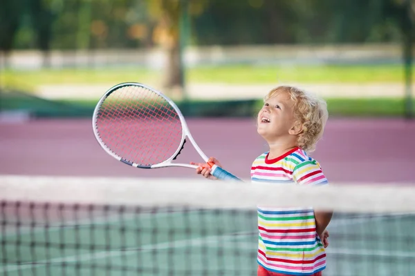 Enfant jouant au tennis sur un court extérieur — Photo