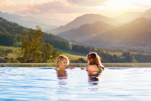 Família em piscina com vista montanha — Fotografia de Stock